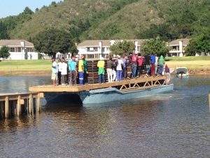 Crew on their way to the Island on a barge.